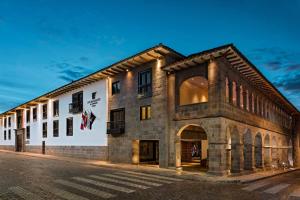 a large stone building on a street at night at JW Marriott El Convento Cusco in Cusco