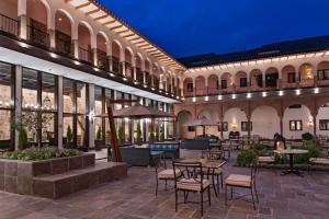 a courtyard at night with tables and chairs at JW Marriott El Convento Cusco in Cusco