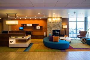 a lobby with a living room with a fireplace at Fairfield Inn & Suites by Marriott Lincoln Southeast in Lincoln