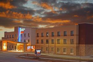 Fairfield Inn & Suites by Marriott Lincoln Southeast في لينكولن: مبنى مستشفى مع علامة مضاءة أمامه