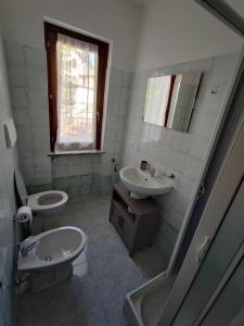 a bathroom with a sink and a toilet and a mirror at Yellow house 2 in Cuasso Al Monte