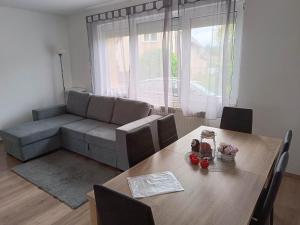 uma sala de estar com uma mesa e um sofá em Nefelejcs Nyaraló-Vendégház em Dunasziget