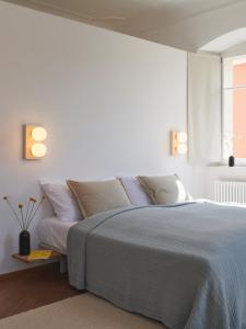 a white bedroom with a bed and a window at Auberge du Mouton in Porrentruy