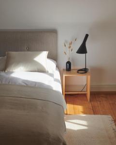 ein Schlafzimmer mit einem Bett und einer Lampe auf einem Tisch in der Unterkunft Auberge du Mouton in Pruntrut