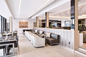 a restaurant with couches and tables and a bar at AC Hotel by Marriott Pleasanton in Pleasanton