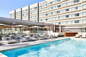 a hotel swimming pool with lounge chairs and a building at AC Hotel by Marriott Pleasanton in Pleasanton