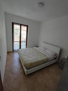 a white bedroom with a bed in a room at Yellow house 2 in Cuasso Al Monte