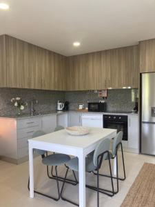 a kitchen with a white table and chairs at PLACIDO RIVER HOUSE APARTAMENTO in Ponte da Barca