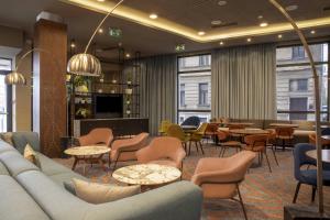 a lobby with a couch and tables and chairs at Courtyard by Marriott Sarajevo in Sarajevo