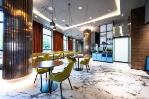 a restaurant with tables and chairs in a room at Courtyard by Marriott Sarajevo in Sarajevo