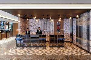 two people standing at a desk in a lobby at Le Méridien Seoul Myeongdong in Seoul