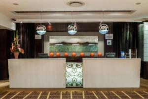 a lobby with two reception desks and a painting at Protea Hotel by Marriott Transit O.R. Tambo Airport in Kempton Park