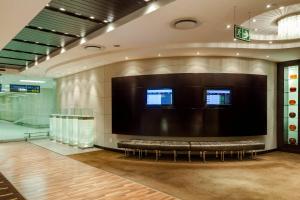 a waiting room with a large screen in a building at Protea Hotel by Marriott Transit O.R. Tambo Airport in Kempton Park