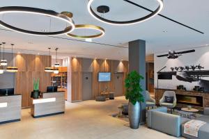 a lobby with a waiting area with a potted plant at Courtyard by Marriott Oberpfaffenhofen Munich South in Gilching
