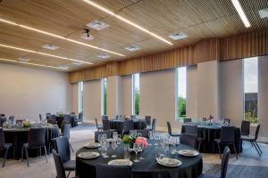 a banquet hall with tables and chairs with black tablecloths at The Ellison, Oklahoma City, a Tribute Portfolio Hotel in Oklahoma City +28 photos
