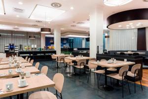 um restaurante com mesas e cadeiras num quarto em Courtyard by Marriott Prague Airport em Praga