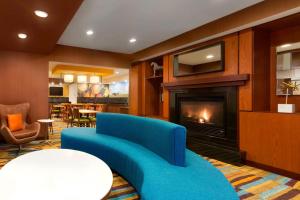 a living room with a blue couch and a fireplace at Fairfield Inn & Suites Midland in Midland