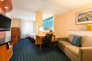 a hotel room with a couch and a bed and a desk at Fairfield Inn & Suites Midland in Midland