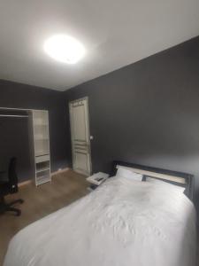 - une chambre avec un lit blanc et un mur noir dans l'établissement Chambre privé dans une maison avec terrasse et jardin salles de bain partagées, à Lille