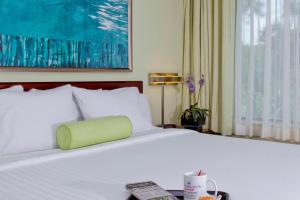 Una habitación de hotel con una cama con una almohada verde. en SpringHill Suites Sarasota Bradenton en Sarasota
