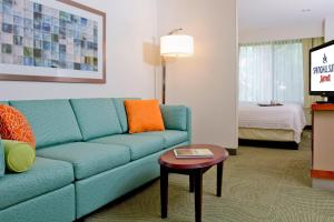 una sala de estar con un sofá azul en una habitación de hotel en SpringHill Suites Sarasota Bradenton, en Sarasota