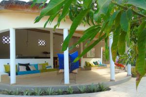 ein Wohnzimmer mit blauen und gelben Möbeln und Bäumen in der Unterkunft WouroBa in Mbodiène
