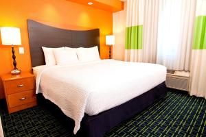 una camera d'albergo con un grande letto con lenzuola bianche di Fairfield Inn & Suites Minneapolis Burnsville a Burnsville