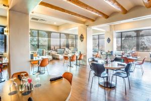 un restaurante con mesas, sillas y ventanas en Sheraton Albuquerque Airport Hotel, en Albuquerque