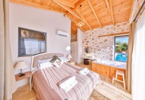 a bedroom with a large bed and a bathroom at Villa No11 Kaş Üzümlü Köyü in Kas