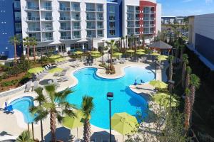 an aerial view of a resort swimming pool with umbrellas at SpringHill Suites Orange Beach at The Wharf in Orange Beach