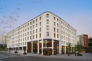 een wit gebouw met veel ramen bij AC Hotel by Marriott Stockholm Ulriksdal in Solna
