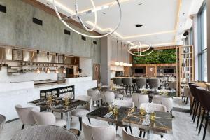 a restaurant with tables and chairs and a bar at AC Hotel by Marriott Stockholm Ulriksdal in Solna