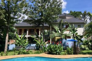 a house with a swimming pool in front of a house at The Vijiji Center Lodge & Safari in Arusha