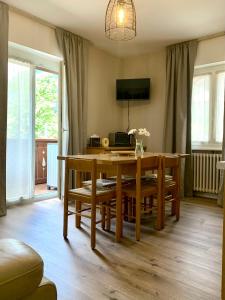 jadalnia z drewnianym stołem i krzesłami w obiekcie DOLOMIA APARTMENTS Pinzolo w mieście Pinzolo