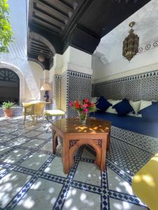 a room with a table with flowers on it at Riad Zouhour in Marrakesh