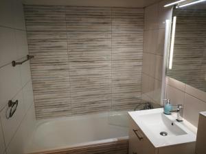 een badkamer met een bad, een wastafel en een douche bij Cozy Tampen-Meerseite- in Neue Tiefe Fehmarn
