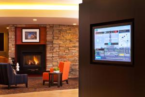 a living room with a fireplace and a television at Courtyard by Marriott Alexandria Pentagon South in Alexandria