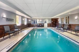 a pool with chairs and tables in a hotel room at Fairfield Inn by Marriott Toronto Oakville in Oakville