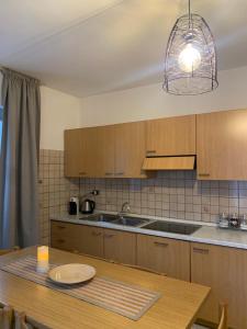 kuchnia z drewnianymi szafkami i drewnianym stołem w obiekcie DOLOMIA APARTMENTS Pinzolo w mieście Pinzolo +6 zdjęć