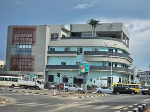 een gebouw met daarvoor geparkeerde auto's bij Burundi Palace Boutique Hotel in Bujumbura