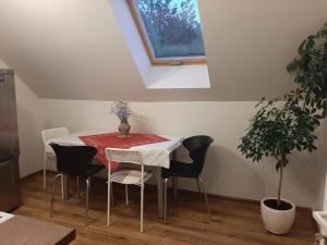 a dining room with a table and chairs and a plant at Prie Ąžuolo in Zarasai