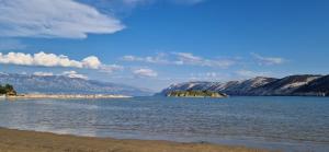 a large body of water with mountains in the background at Apartment Dragan i Slavica in Lopar