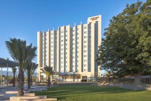 a large building with a park in front of it at Courtyard by Marriott Saltillo in Saltillo