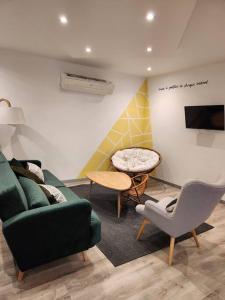 a living room with a green couch and a table at Appartement avec baignoire - Hautvillers in Hautvillers