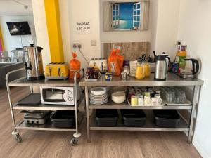 a kitchen with a cart with a microwave on it at Blue Room Hostel Newquay in Newquay