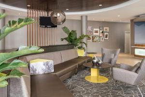 a living room with a couch and chairs and a tv at SpringHill Suites by Marriott Lafayette South at River Ranch in Lafayette