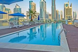 a swimming pool with a city skyline in the background at Vivid 2-bedroom Marina view in Dubai