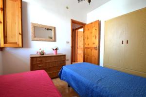 a bedroom with a blue bed and a wooden cabinet at Casa vacanza vicino spiaggia-ll23 in San Foca