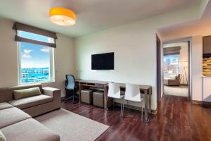 a living room with a couch and a desk with a tv at Element Boston Seaport District in Boston