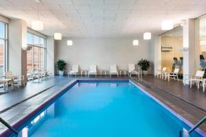a swimming pool in a room with chairs and tables at Element Boston Seaport District in Boston